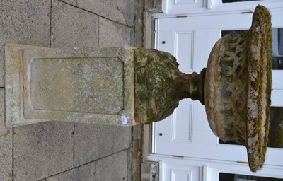 Lot 1306 - #A weathered composition garden urn raised on a square column base, 75cm diameter, 140cm high