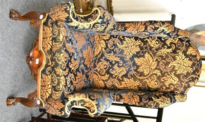 Lot 1333 - A wing back armchair, upholstered in blue and gold chenille, raised on claw and ball feet