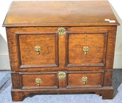 Lot 1349 - An 18th century joined oak chest with hinged lid above two lozenge carved panels and a drawer below