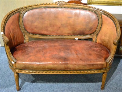 Lot 1350 - An early 20th century beech framed sofa upholstered in close nailed leather