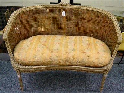 Lot 1380 - A cream painted five piece bergere suite, comprising two seater sofa, a pair of tub chairs and...