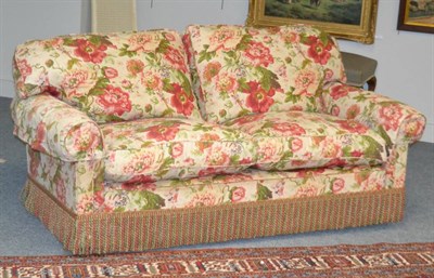 Lot 1391 - A floral printed three seater sofa with squab cushions, 194cm wide