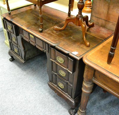 Lot 1466 - A stinkwood desk fitted six small drawers around a shaped apron and raised on claw and ball feet