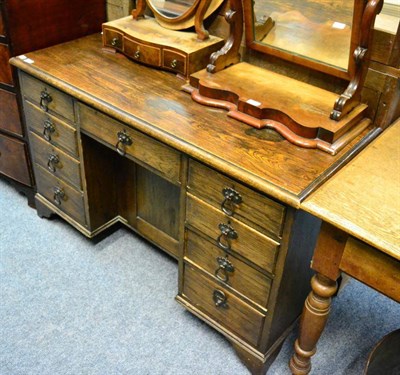 Lot 1473 - Oak kneehole desk fitted with nine drawers