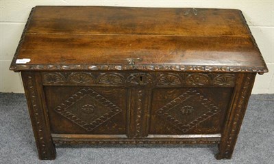 Lot 1520 - A 17th century joined oak chest with hinged lid above four carved lozenge panels