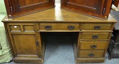 Lot 1575 - An Edwardian oak desk, fitted with drawers and a cupboard