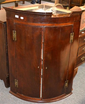 Lot 1580 - ^A George III mahogany bow fronted corner cupboard