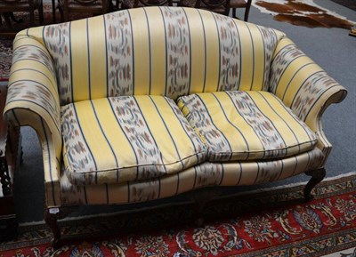 Lot 1602 - A late 19th/early 20th century two seater sofa, recovered in yellow striped fabric, raised on...