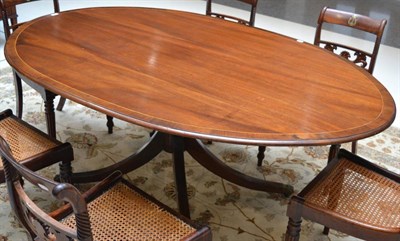 Lot 1605 - A 19th century mahogany dining table of Regency style, the oval crossbanded top on a gun barrel...