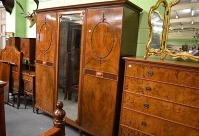 Lot 1621 - A large walnut bedroom suite comprising a triple door wardrobe, five drawer chest, pair of...