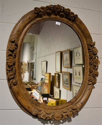 Lot 1799 - An 18th century French oak framed oval wall mirror decorated with flowers