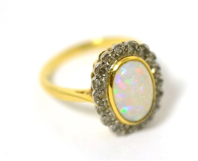 Lot 13 - An opal and diamond cluster ring, an oval cabochon opal in a yellow bezel setting within a...