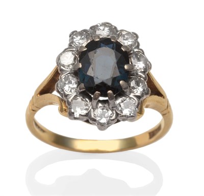 Lot 14 - A sapphire and diamond cluster ring, an oval cut sapphire within a border of round brilliant...