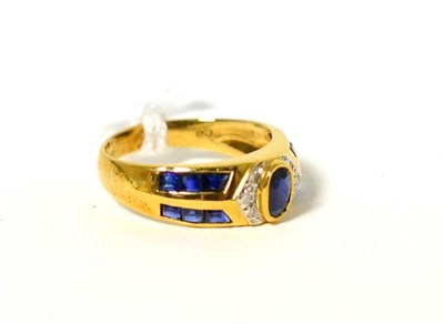 Lot 75 - A sapphire and diamond ring, an oval cut sapphire in a yellow rubbed over setting between pavé set