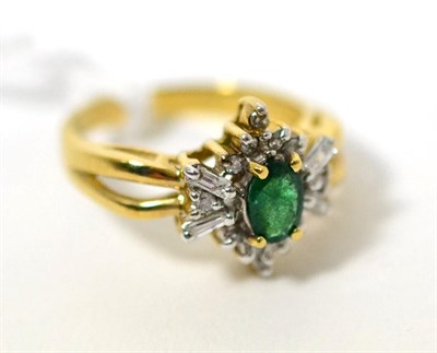 Lot 86 - An emerald and diamond ring, an oval cut emerald in a yellow claw setting within a border of...