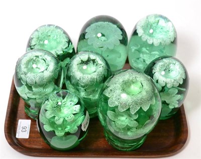 Lot 93 - A collection of eight Victorian green glass dumps, each containing a vase of flowers, the...