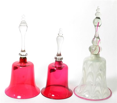 Lot 118 - Two ruby glass table bells, tallest 30cm high; and a latticino and glass table bell (3)