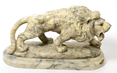 Lot 124 - A carved white and grey mottled marble figure of a lion standing, with glass eyes, on marble...