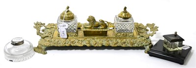 Lot 141 - A large brass double inkwell, the centre compartment with a lion cover, two inkwells and two Parker