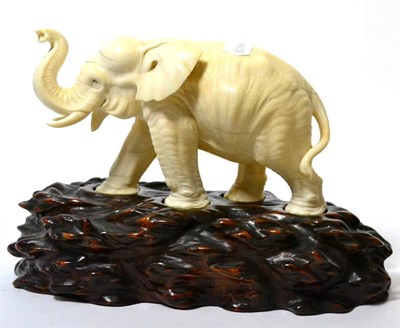 Lot 150 - A Japanese ivory figure of a standing elephant, Meiji, naturalistically modelled walking, signed to