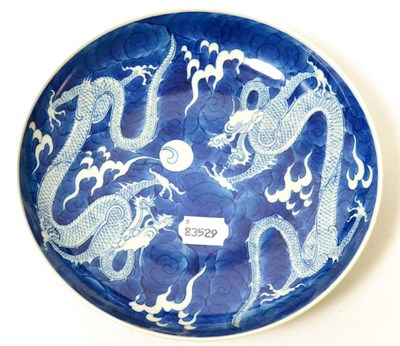 Lot 162 - A Chinese porcelain saucer dish, painted in underglaze blue with dragons chasing the flaming pearl