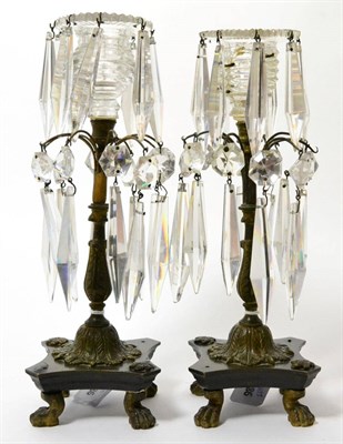Lot 164 - A pair of Regency cut glass and bronze lustres, hung with faceted drops, on paw feet, 26cm high