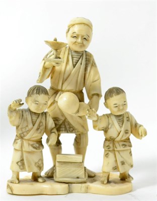 Lot 191 - A Japanese ivory okimono, Meiji period, as a juggler holding a spatula and gourd, two children...