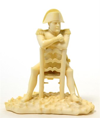 Lot 199 - A Dieppe ivory figure of Napoleon, late 19th century, sitting backwards on a chair, on a...