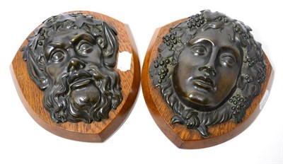 Lot 214 - A pair of 19th century bronze masks of Pan and Bacchus, on oak shields, 23cm