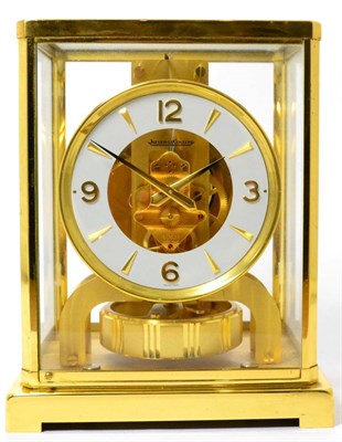 Lot 215 - A brass atmos clock, signed Jaeger LeCoultre, case with glass panels, white chapter ring with...