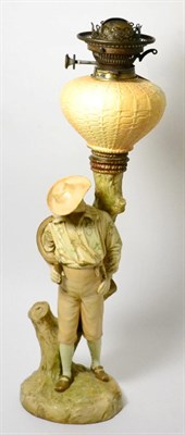 Lot 236 - A Royal Worcester blush ivory oil lamp in the form of a farmhand, shape 964, 58cm high