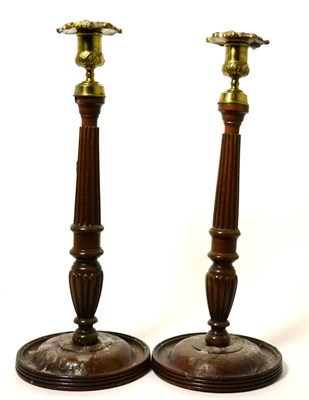 Lot 239 - A pair of brass mounted turned wood candlesticks, 19th century, with foliate sconces on fluted...